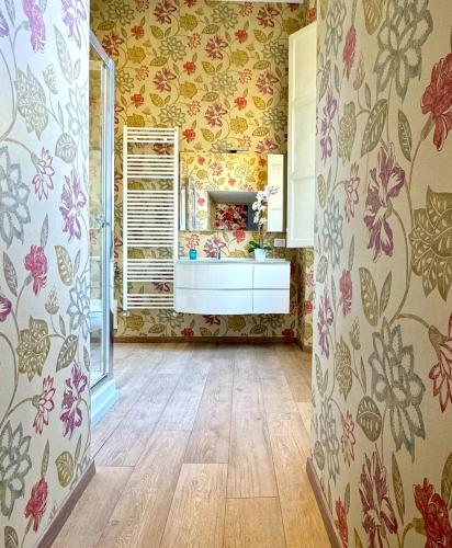 a bathroom with floral wallpaper on the walls at Casa Cenami in Lucca