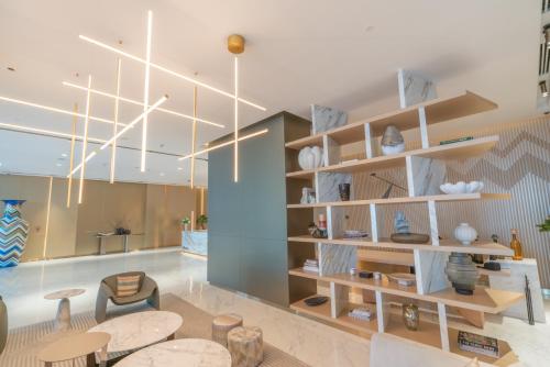 a room with tables and chairs and a chandelier at Aven Apartment Dubai 2BR-2209 in Urban Oasis by Missoni-Business Bay Dubai in Ghantoot