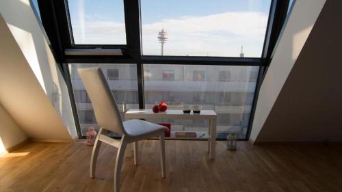 a table and chairs in a room with a large window at Hauptbahnhof 32 in Vienna