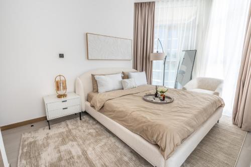 a white bedroom with a bed and a table at Aven Apartment Dubai 2BR-2209 in Urban Oasis by Missoni-Business Bay Dubai in Ghantoot