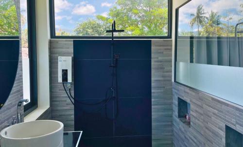 a bathroom with a shower and a sink at The White House Beach Apartments Koh Phangan in Ban Nua