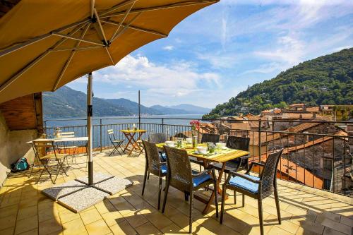 a patio with a table and chairs and an umbrella at Casa Sofia in Cannobio