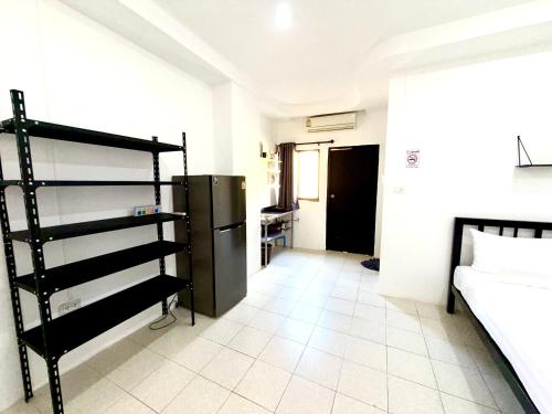 Habitación con cama y nevera. en Patong Canal Villa 107, en Patong Beach