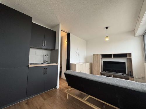 - une cuisine avec un canapé au milieu d'une pièce dans l'établissement Appt Studio cabine LA ROCHELLE - LR240-207, à La Rochelle