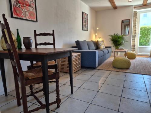 a living room with a table and a couch at La Maison Neuve Gîtes in Madré