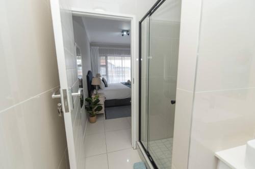 een badkamer met een douche en een bed in een kamer bij The Sapphire in Gqeberha