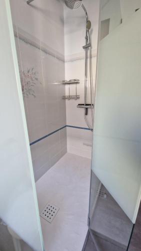 une douche avec une porte vitrée dans une salle de bain dans l'établissement Appartement au premier étage dans maison de charme avec grand jardin au RDC, à Banyuls-sur-Mer