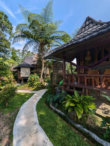 a house with a walkway next to a building at Satu Lingkung in Tetebatu