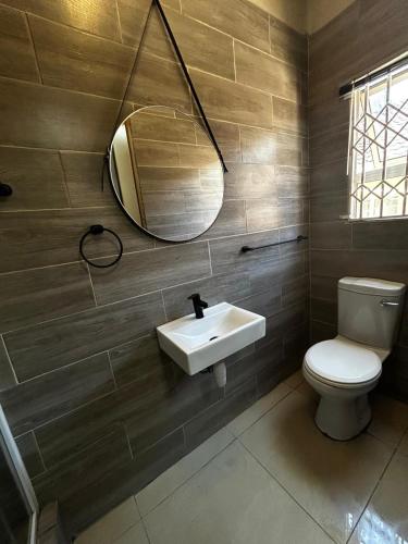 a bathroom with a sink and a toilet and a mirror at Sunnyside Haven in Grahamstown