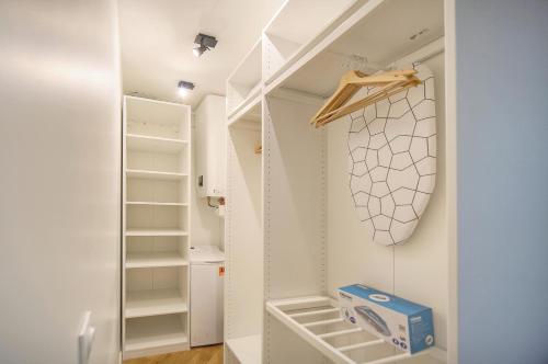 Elle comprend un petit placard avec des murs blancs et des étagères blanches. dans l'établissement charmant 2 pieces proche plage du midi A1B266, à Cannes