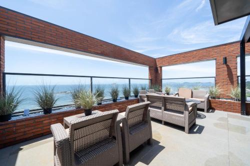 a patio with chairs and tables and windows at Hound Hotel Deacheon Beach in Boryeong