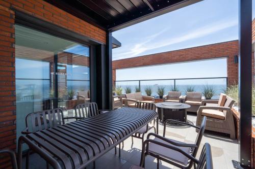 a patio with a table and chairs and windows at Hound Hotel Deacheon Beach in Boryeong