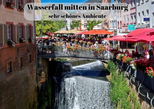 a bridge over a river with a waterfall at Ferienwohnungen Im Kimmelreich in Irsch