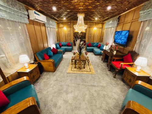 a living room with blue couches and a tv at Shabistan Premium Houseboats in Srinagar