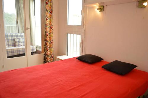 - une chambre dotée d'un lit rouge avec deux oreillers noirs dans l'établissement Appartement 2 pièces 5 couchages ARGELES SUR MER AR350-0D3, à Argelès-sur-Mer