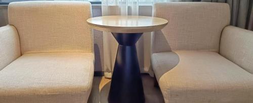 a table inbetween two chairs with a table between them at 天门山云尚景豪酒店 in Zhangjiajie