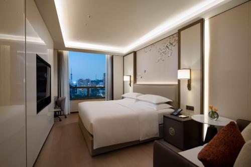 a bedroom with a large white bed and a couch at Yuexiu Hotel Guangzhou,Curio Collection by Hilton-Free shuttle between hotel and Exhibition Center during Canton Fair & Exhibitor Registration Counter in Guangzhou