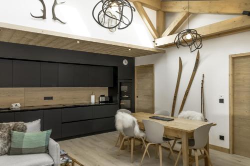 une cuisine et une salle à manger avec une table et des chaises en bois dans l'établissement Nid d'Aigle - Balcon - Magnifique vue Mont Blanc, aux Houches