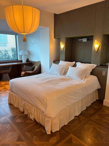 - une chambre avec un grand lit blanc et un salon dans l'établissement Villa Pâquerette, Marseille, à Marseille