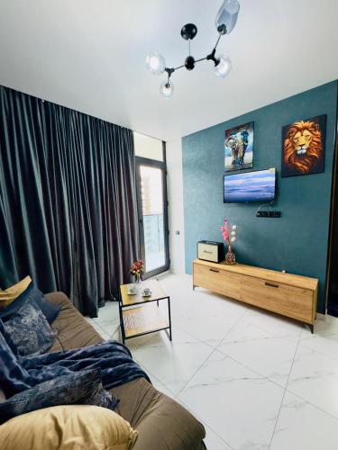 a living room with a couch and a blue wall at Квартира у Моря in Batumi