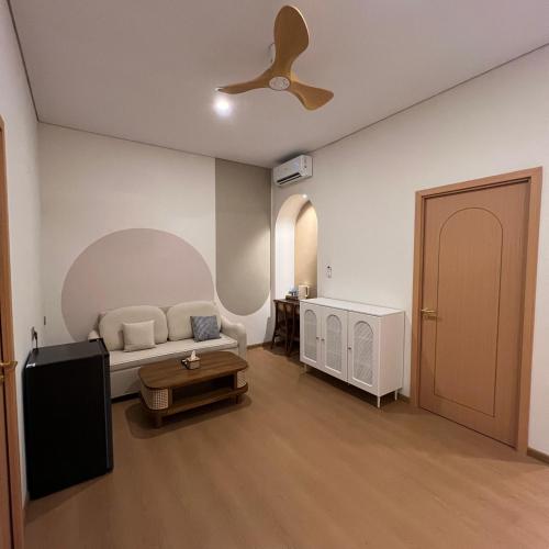 a living room with a couch and a ceiling fan at Casabella Homestay 207 Batam Penuin in Nagoya