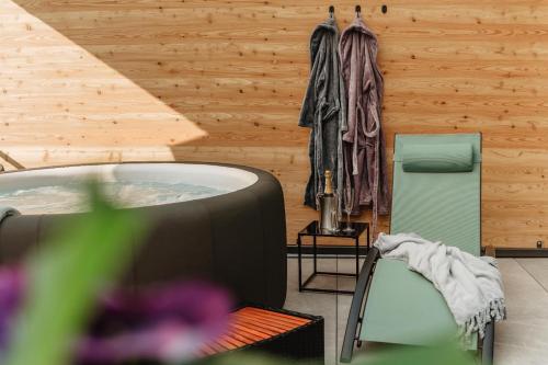 a room with a hot tub and a chair at Rabenstein Suiten in Zwiesel
