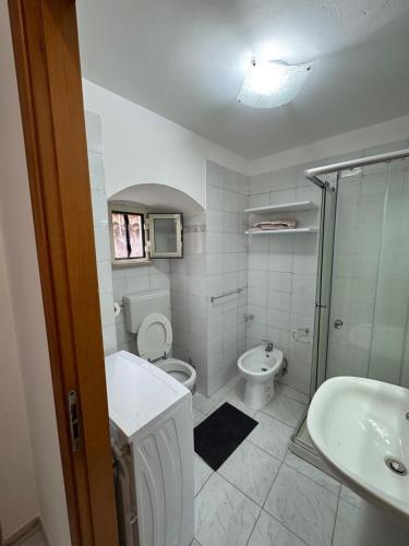 a white bathroom with a toilet and a sink at Casa FLAVIA in Serracapriola