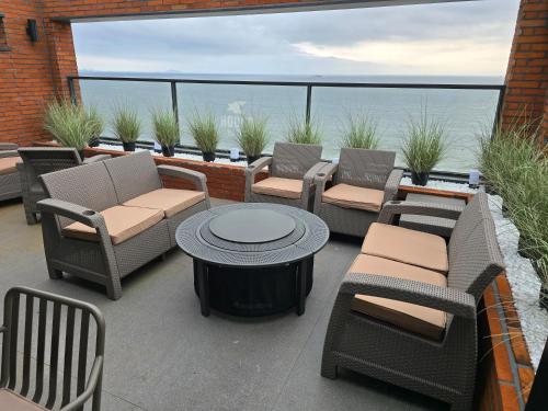 a patio with chairs and a table with a view of the ocean at Hound Hotel Deacheon Beach in Boryeong