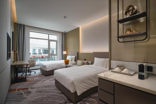 a hotel room with two beds and a desk at Crowne Plaza Wuhan Tianhe Airport by IHG in Wuhan