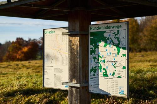 a sign on a wooden post with a map at AlbCamping Westerheim in Westerheim