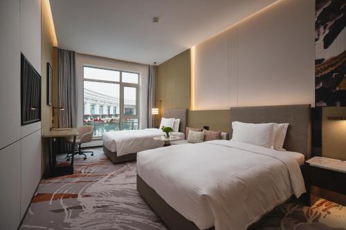 a hotel room with two beds and a window at Crowne Plaza Wuhan Tianhe Airport by IHG in Wuhan