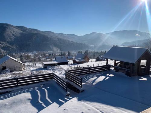 a swimming pool covered in snow with mountains in the background at KOLO Котеджний комплекс in Tatariv