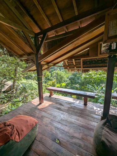a wooden deck with a bench on top of it at Satu Lingkung in Tetebatu