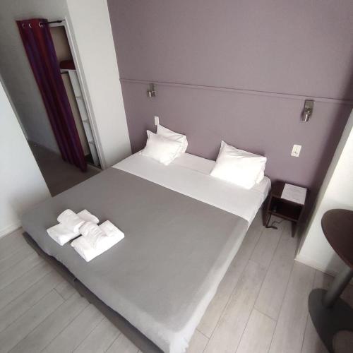 a small room with a bed with two towels on it at Hôtel De La Gare Nantes Station Hotel Nantes in Nantes