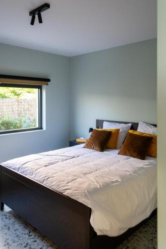 a bedroom with a large bed with a window at Villa Couleur in Diksmuide