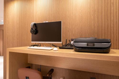 a desk with a computer and a monitor and a printer at Hound Hotel Deacheon Beach in Boryeong