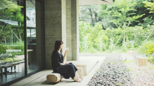 a woman sitting on a bench in front of a building at SOKI ATAMI - Vacation STAY 01361v in Atami