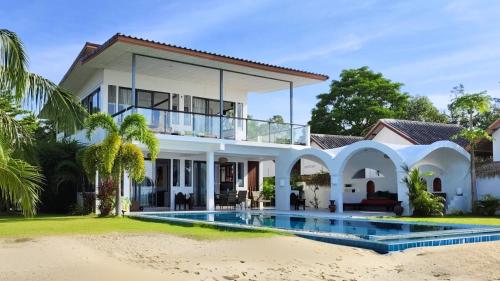 a house on the beach with a swimming pool at The White House Beach Apartments Koh Phangan in Ban Nua