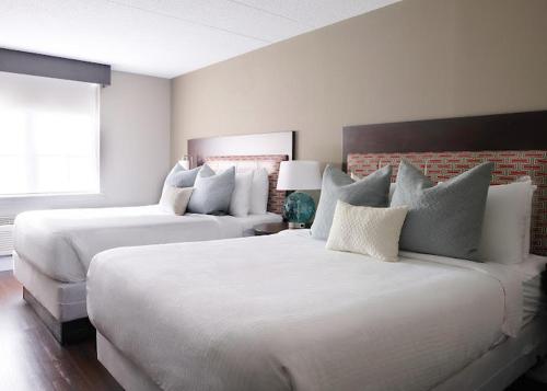 a bedroom with two beds and a brick wall at Comfort Inn & Suites Pottstown Eastern Gateway in Pottstown