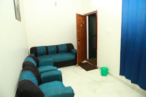 a living room with two blue couches and a mirror at Rithu's Inn in Yelagiri