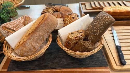 two baskets filled with different types of bread on a table at Appart Hotel Odalys City Toulouse Centre Compans Caffarelli in Toulouse