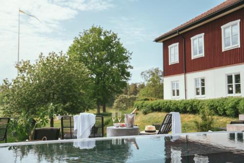 a patio with a table and chairs next to a pool at Fågelbro Säteri in Värmdö