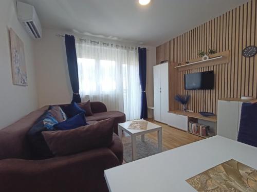 a living room with a couch and a table at Apartman s parkingom, blizu Akva parka, Natura Lux - Green Hill, Sokobanja in Soko Banja