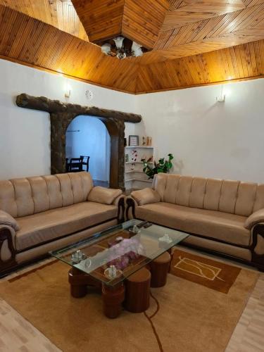 un soggiorno con due divani e un tavolo di RUWAMU Guesthouse a Naivasha