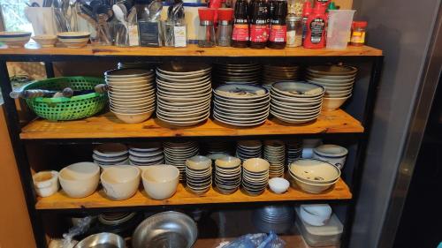 a shelf with a bunch of plates and bowls at Little House in KhauPha, Mu Cang Chai - homestay, cuisine, cafe in Mù Cang Chải
