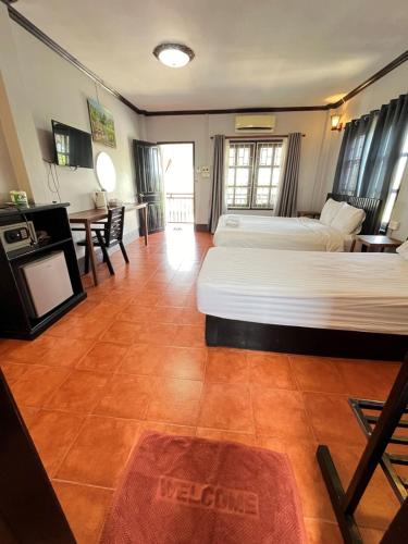 a hotel room with two beds and a table at Nice view guesthouse in Vang Vieng