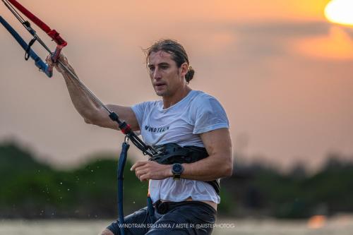 a man is holding onto a handle on a board at Club Mango Resort in Kalpitiya