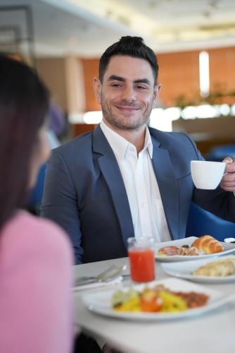 a man sitting at a table with a plate of food at Radisson Hotel Colombo in Colombo