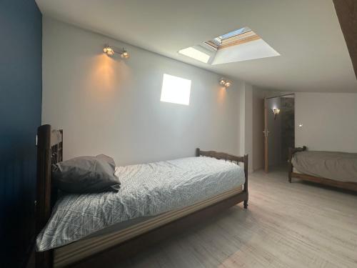 une chambre avec un lit et une lucarne dans l'établissement Villa avec vue imprenable, Au pied du Rocher, à Aiguilhe