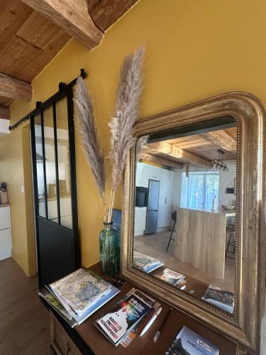 un miroir sur une table avec un vase sur la table dans l'établissement Villa avec vue imprenable, Au pied du Rocher, à Aiguilhe